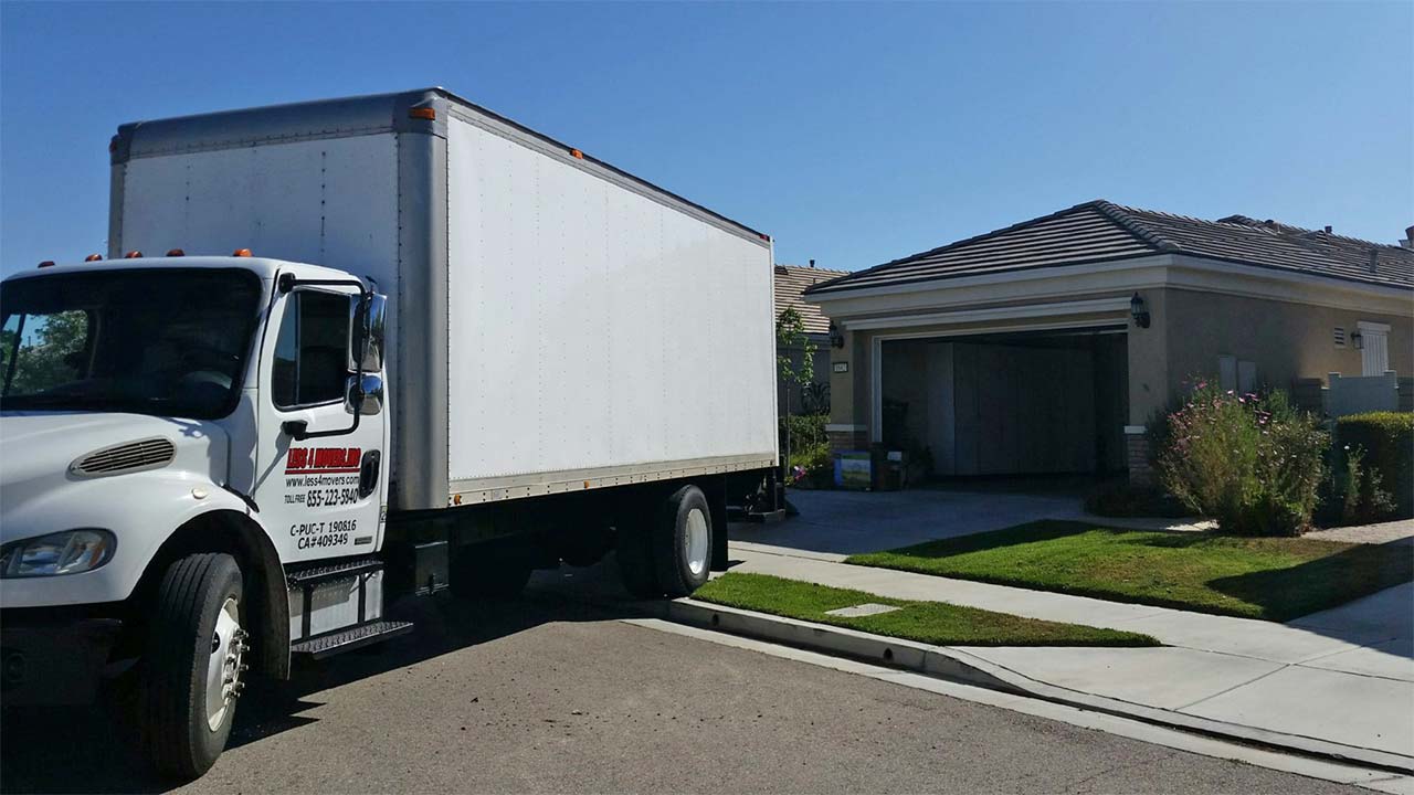 Residential movers carrying boxes into a house